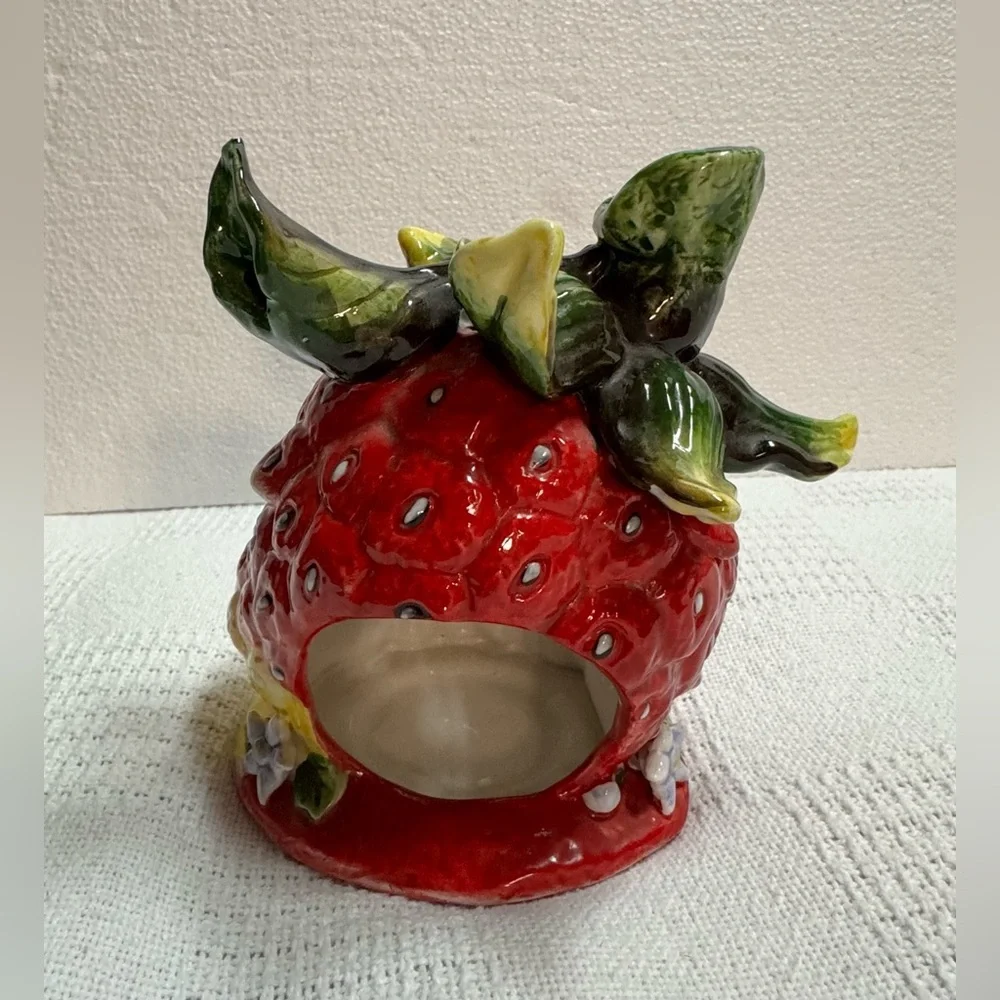 This is a vintage ceramic strawberry candle or tealight holder,